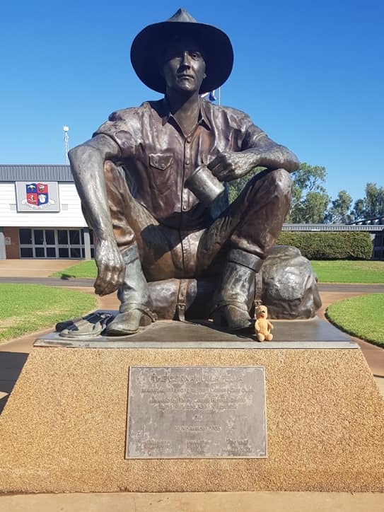 A teddy bear in a photo with the Cunnamulla Fella in South-West Queensland on a sunny day. 