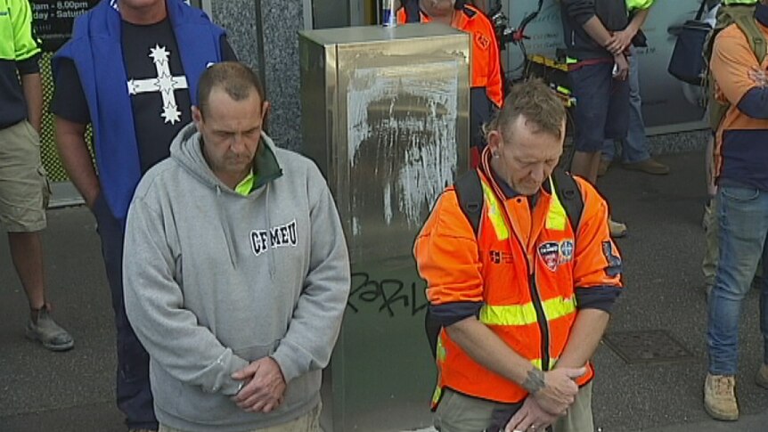 Workers held a minute's silence in respect of three people killed when a wall collapsed on Swanston St.
