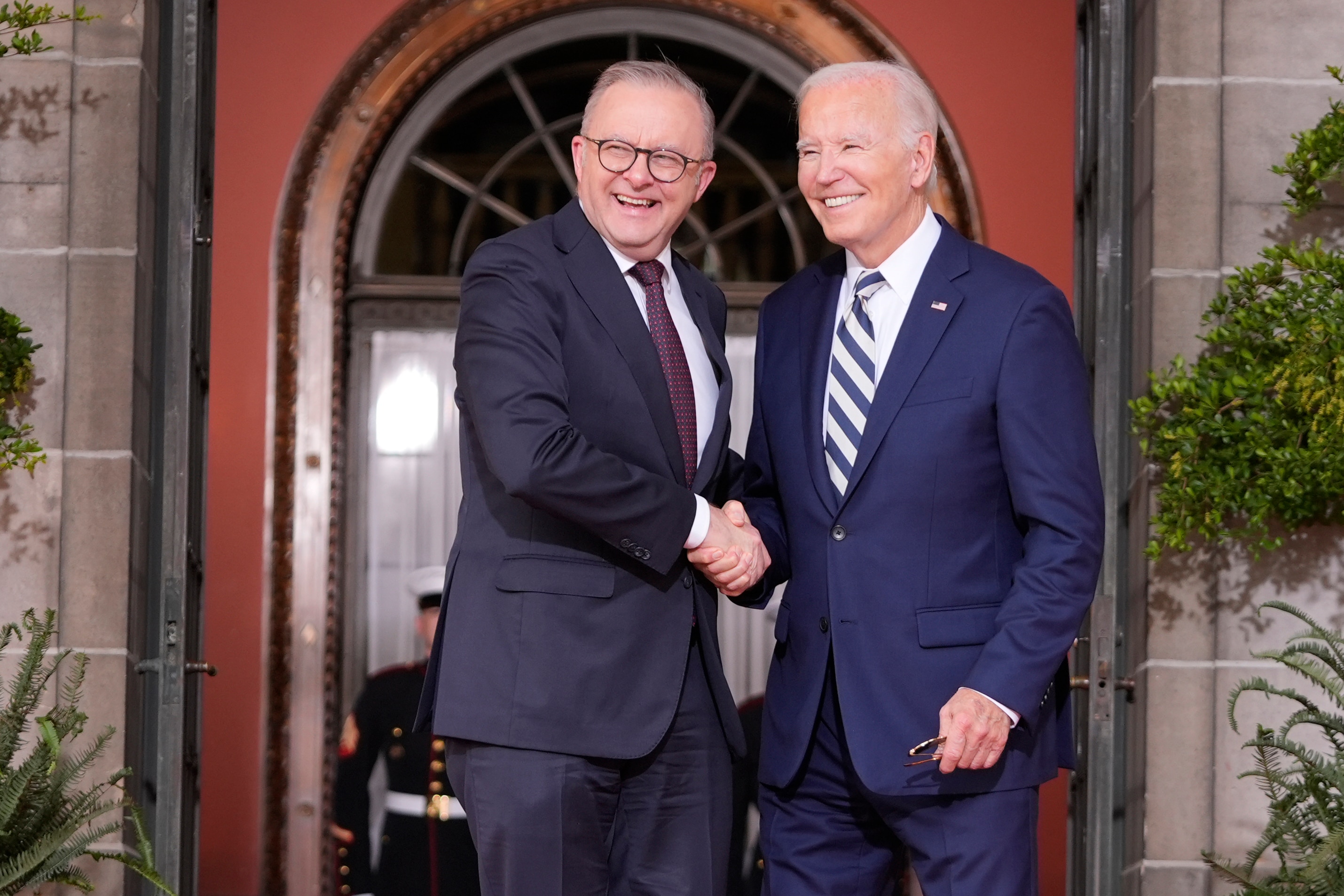Anthony Albanese and Joe Biden shake hands, smiling. 