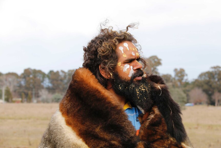 Clinton Pryor, dressed in animal fur, looks towards Canberra.
