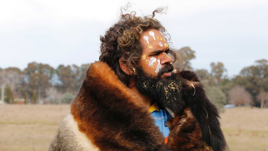 Clinton Pryor, dressed in animal fur, looks towards Canberra.