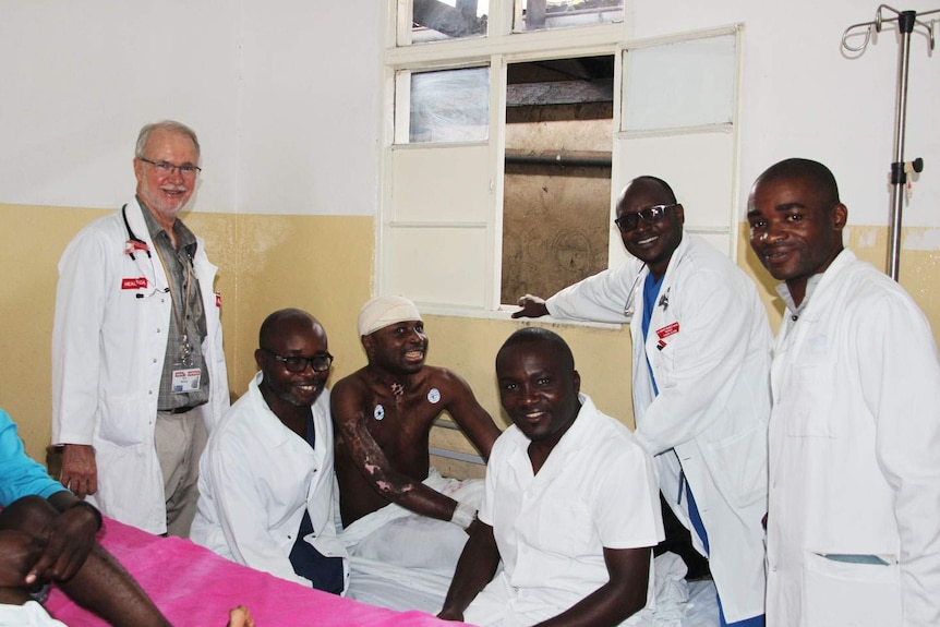 Dr Neil Wetzig with a long-term burns patients and the health team on a ward round.