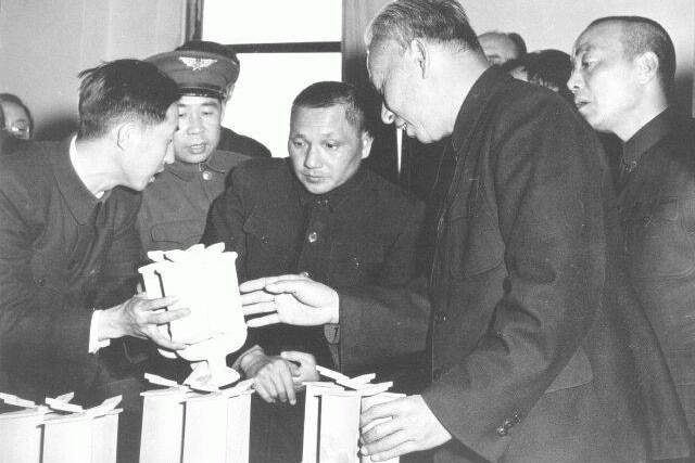 A black and white photo of Deng Xiaoping at a factory
