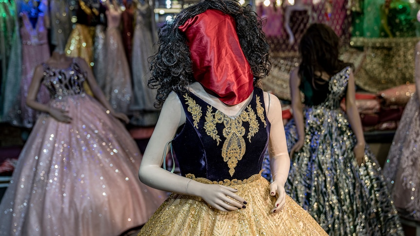 A mannequin in a Kabul shop has red fabric bag covering its face.