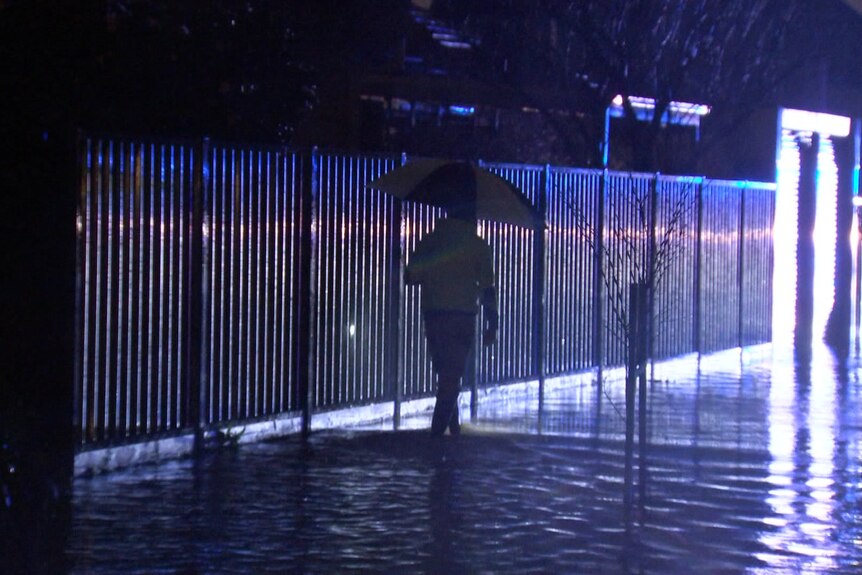 A person walking through floodwater.