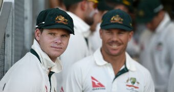 Steve Smith and Cameron Bancroft look at the field from the sidelines.