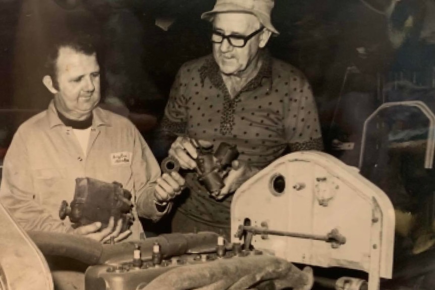Black and white photo of two men in mechanic shop