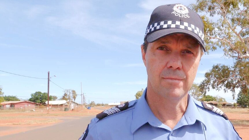 Police officer Chris Fox standing in front of tree.