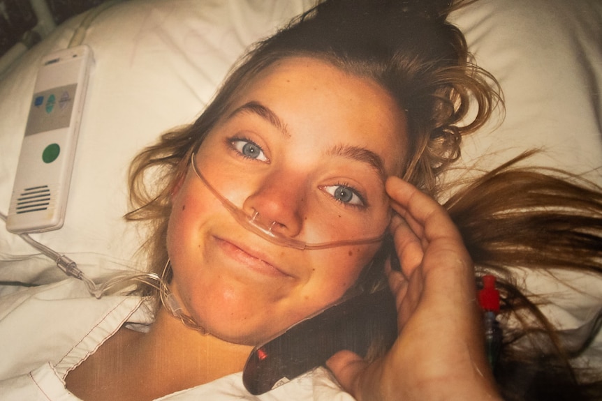 young woman looking up from hospital bed, tubes in nose