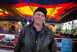 Elwin Bell sits in front of a dodgem car ride.