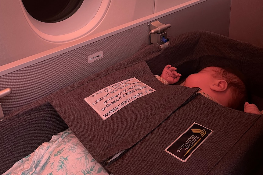 A baby sleeps in an airplane capsule