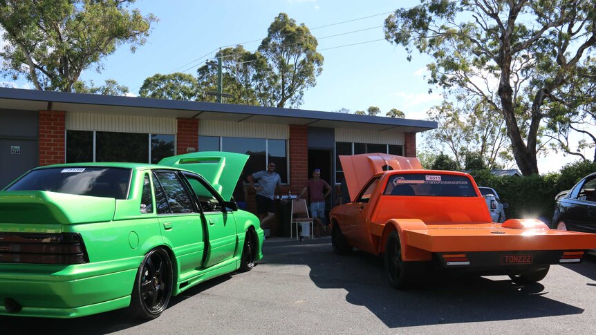 Souped up cars parked in front of the motel.