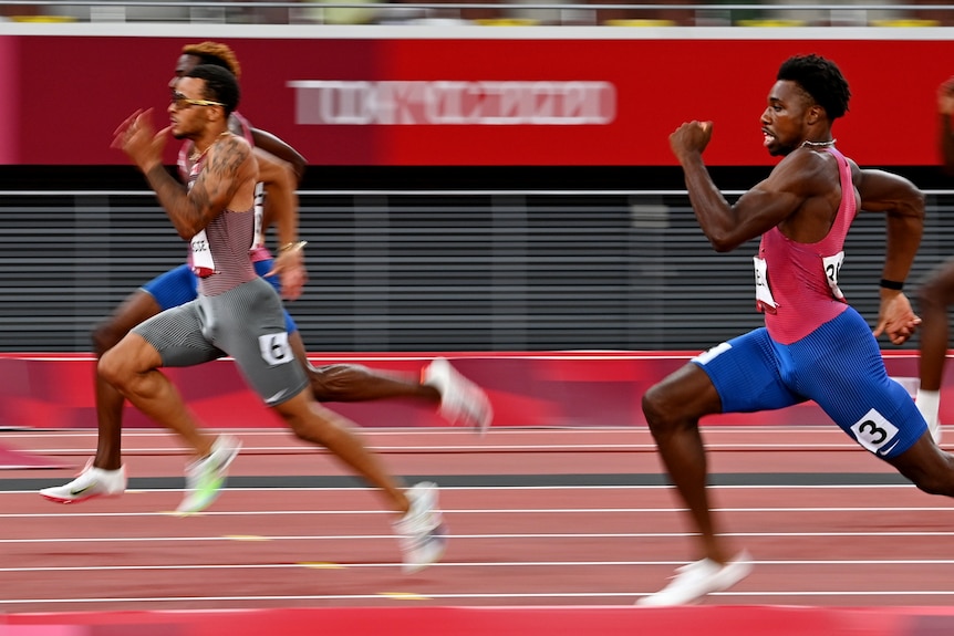 Andre De Grasse (centre) runs past his American rivals in Tokyo.