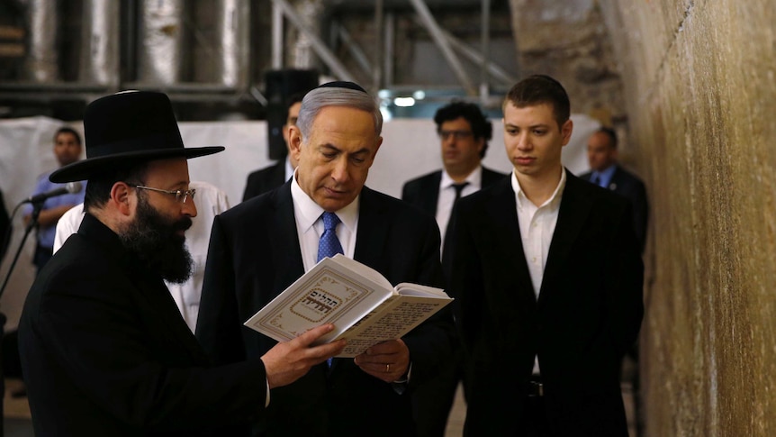 Benjamin Netanyahu stands with his son and a rabbi next to the Western Wall.