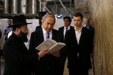 Benjamin Netanyahu stands with his son and a rabbi next to the Western Wall.
