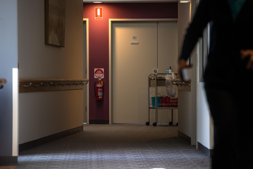 A worker walks down a hallway in an aged care home.