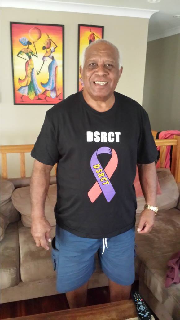 Fijian rugby league pioneer Amen Gutugutuwai wears a shirt supporting research for the cancer which claimed daughter Janice