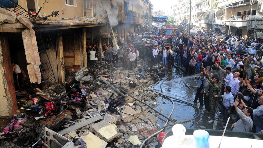 Syrians inspect the damage caused by an explosion in the capital of Damascus on Monday.