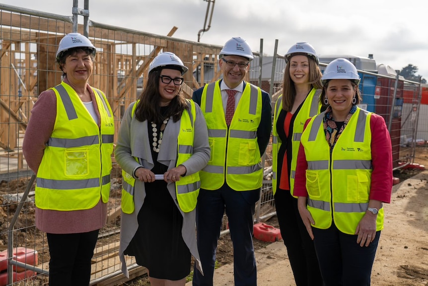 five politicians stand side-by-side at construction site