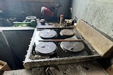 A stovetop is covered in thick black oil from a spill cause by damage from floods in Broadwater New South Wales.