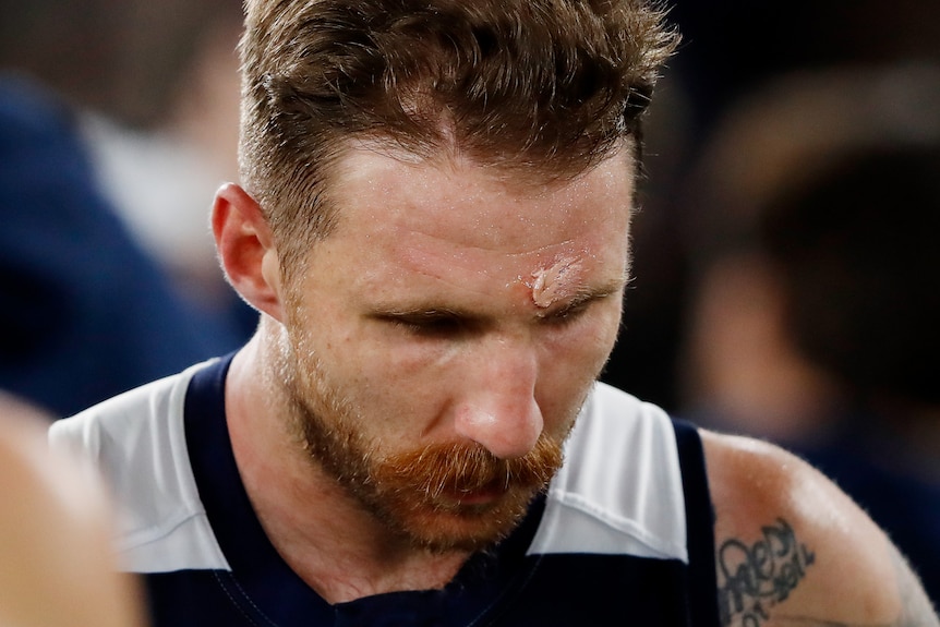 Zach Tuohy looks down. He has a visible cut above his left eyebrow