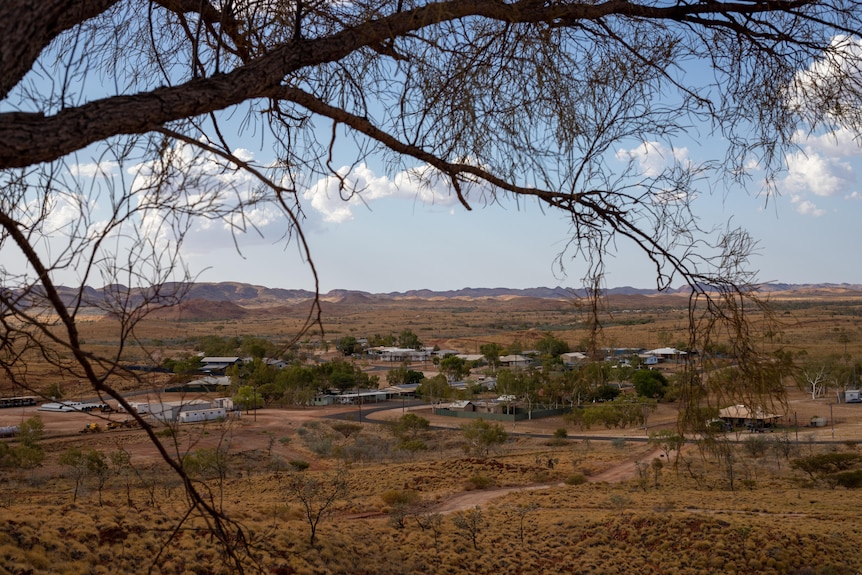 an elevated view of an outback town surrounded by parched a hilly landscape
