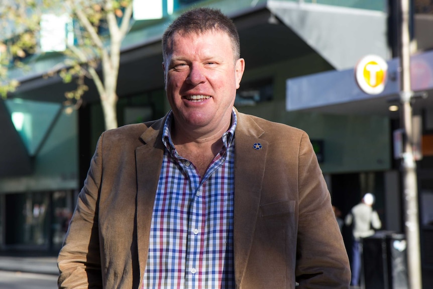 Uniting Church Reverend Simon Hansford standing outside of the Kings Cross train station on Darlinghurst Rd.