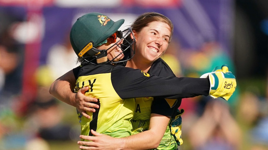 Georgia Wareham celebrates with Alyssa Healy by hugging and smiling