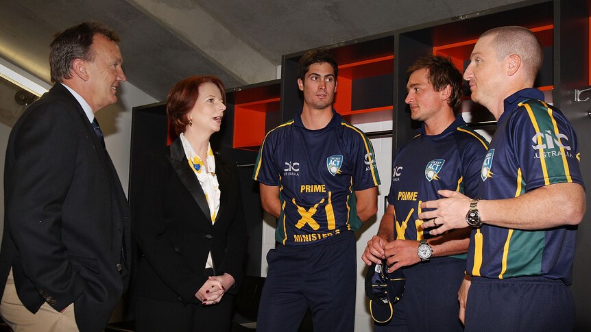 Prime Minister Julia Gillard chats with players before rain forced the abandonment of the tour match against Sri Lanka