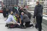 Injured people are given assistance after a car ploughed into pedestrians on Westminster Bridge in a terrorist attack.