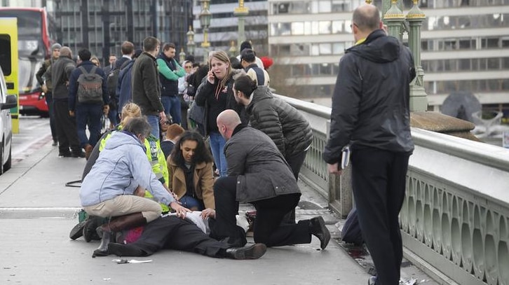 Injured people are given assistance after a car ploughed into pedestrians on Westminster Bridge in a terrorist attack.