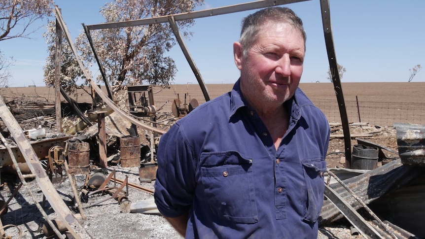 Terry Smith stands in the ruins of his workshop
