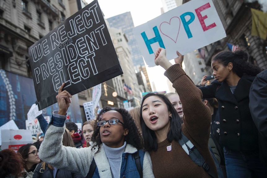 Demonstrators hold signs during a rally outside Trump Tower in New York on Saturday, Nov 12, 2016.