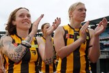 Hawthorn AFLW players clap their hands as they leave the MCG in a preseason match.