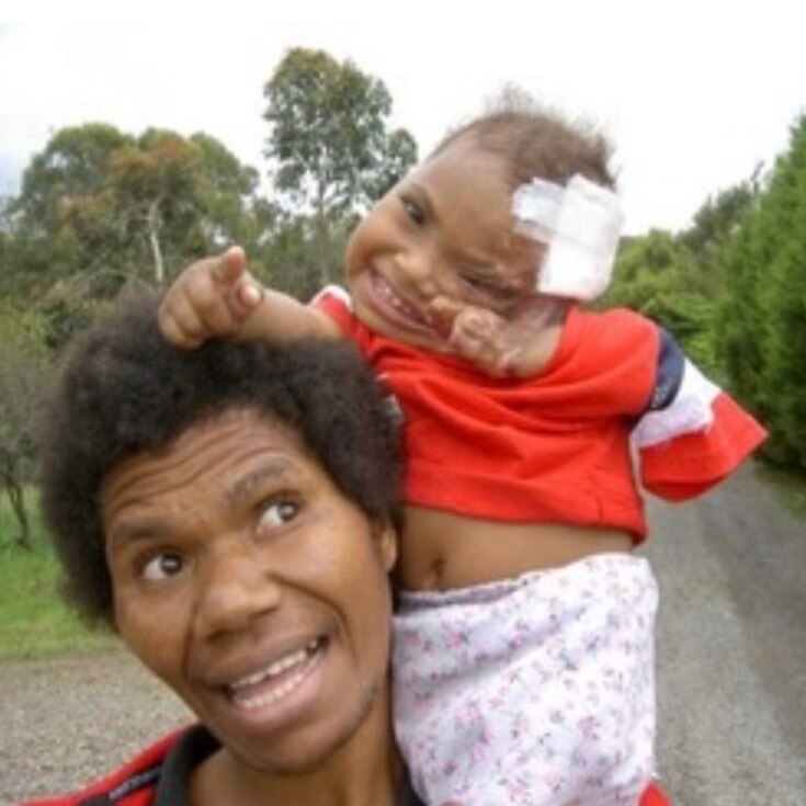 Emai as a baby sitting on her mother Elsie's shoulders.
