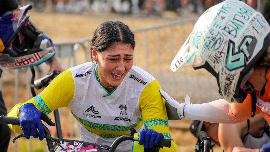 A woman celebrates after winning a BMX race