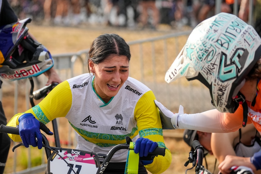 A woman celebrates after winning a BMX race