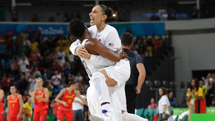 United States' Diana Taurasi leaps into the arms of teammate Angel McCoughtry as they celebrate their win over Spain