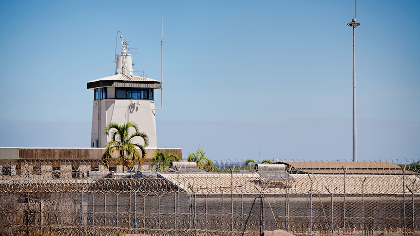 The exterior of the Don Dale Youth Detention Centre, showing the building surrounding by a barbed wire fence.