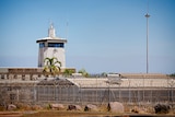 The exterior of the Don Dale Youth Detention Centre, showing the building surrounding by a barbed wire fence.