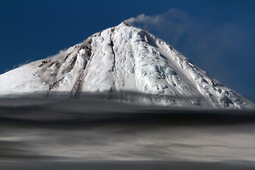 A picture of a snow-capped mountain set against a blue sky