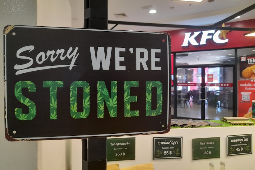 A sign reading "Sorry, we're stoned" with a KFC in the background. 