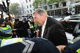 Cardinal George Pell getting out of his car outside the Melbourne Magistrates' Court.