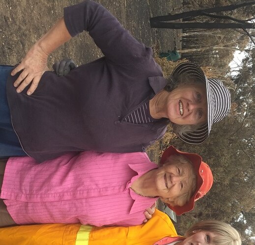Three women standing on the burnt out site of Joy Horton's property in the bush at Carwoola, near Canberra.