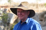 Mid shot of man facing the camera, wearing a hat.