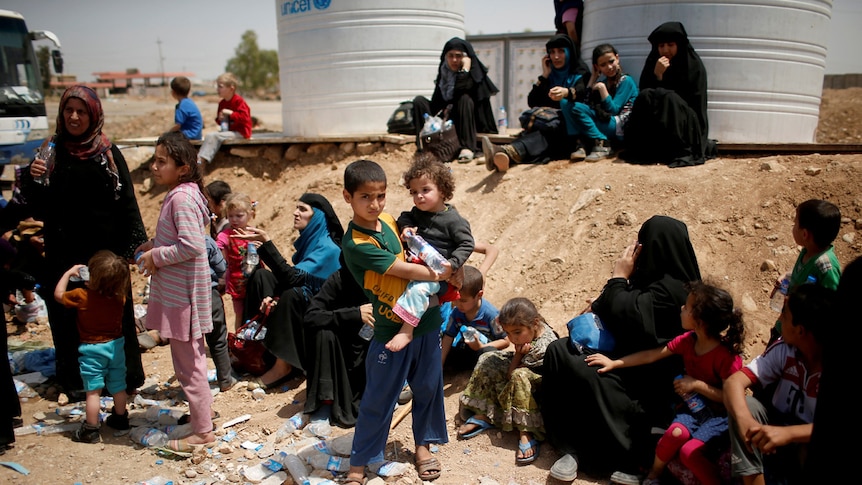 Displaced Iraqis wait to move to a safe place as Iraqi forces battle with Islamic State militants, in western Mosul.