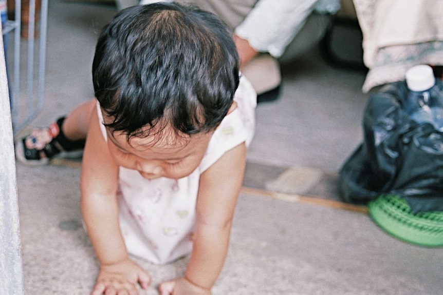 A baby with black hair pictured crawling in Phnom Penh, Cambodia.
