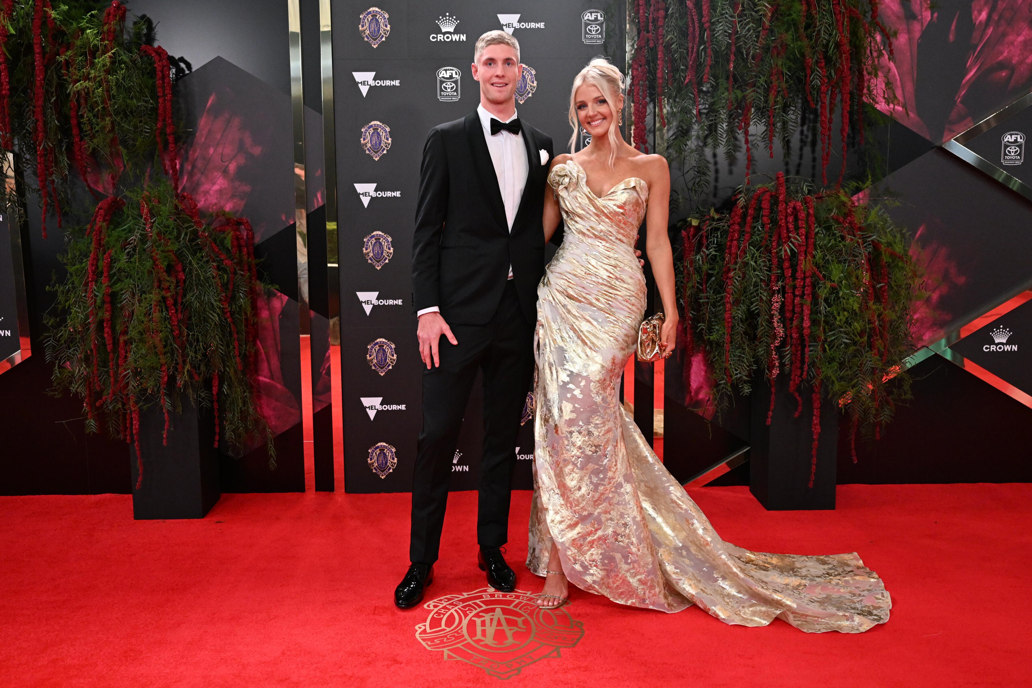 Western Bulldogs' Tim English with partner and netballer Rudi Ellis looking radient in gold.