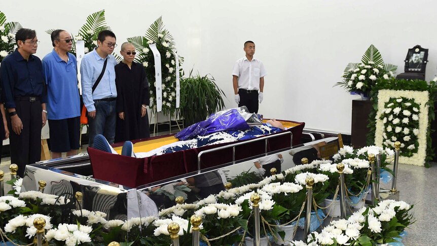 Relatives of late Chinese dissident Liu Xiaobo stand next to the casket during his funeral.