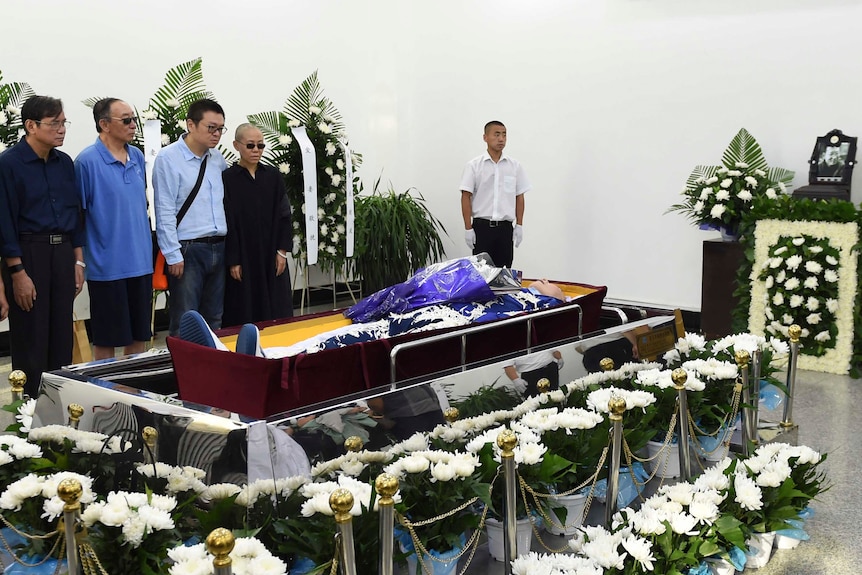 Relatives of late Chinese dissident Liu Xiaobo stand next to the casket during his funeral.